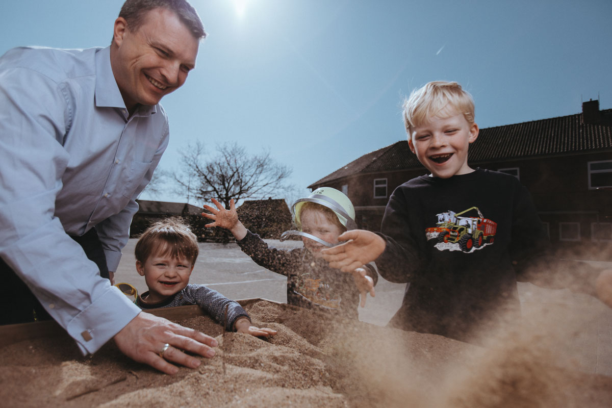 Andreas Herbst spiel mit seinen Kindern im Sand. 